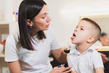 A woman speech therapist deals with the child and teaches him the correct pronunciation and competent speech.