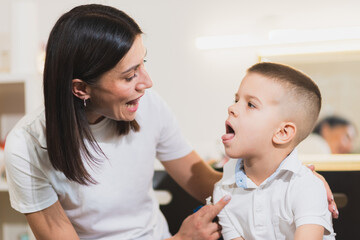A woman speech therapist deals with the child and teaches him the correct pronunciation and competent speech.