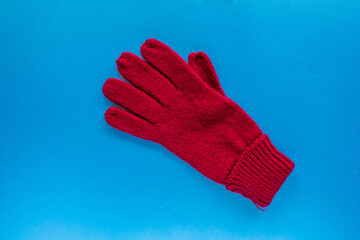 Top view red glove isolated on blue background.