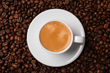Cup of hot drink on beans, top view. Coffee Break