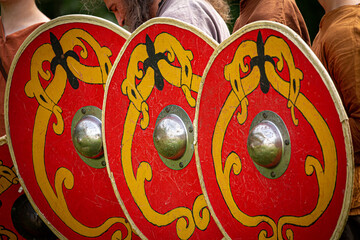 Red wooden Viking shields with yellow pattern on display