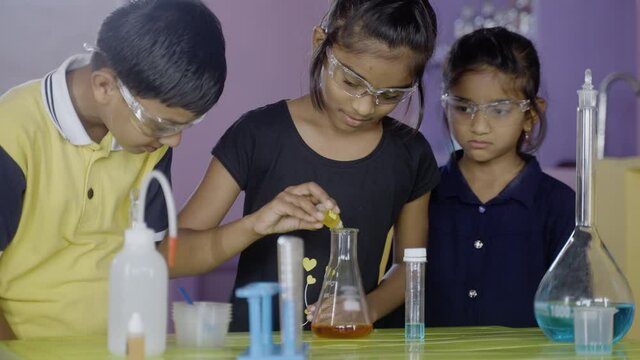 Kids got sad over not able to execute chemistry lab experiment after mixing chemical into flask - concept of fun education, learning process, childhood development and socialising at school.