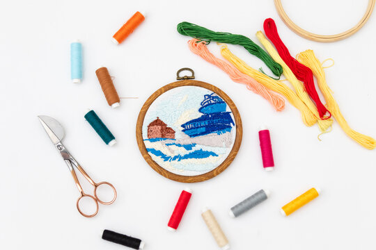Technique embroidery stitch depicting a weather station on the Sniezka mountain. Embroidery tools and materials: floss threads, scissors and hoops