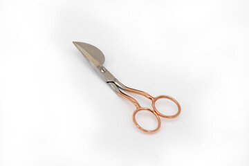 Special metal scissors for applications with a curved blade on a white background. Needlework tool