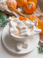 Tangerines and heart shaped marshmallow slices with latte coffee