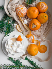 Christmas still life. Tangerines and heart shaped marshmallow slices with latte coffee