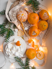 Christmas still life with tangerines and marshmallows in cup of latte coffee