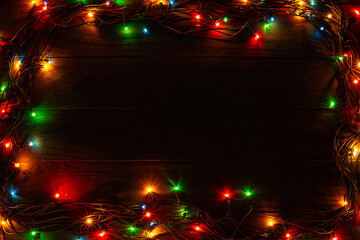 Christmas wooden board black background garland  top view copyspace