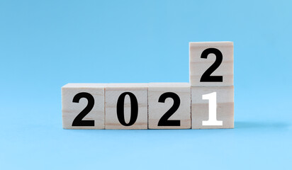 woodblocks cubes with a number 2021 change to 2022 blue background. new year 2021- 2022 concept.