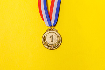 Simply flat lay design winner or champion gold trophy medal isolated on yellow colorful background....
