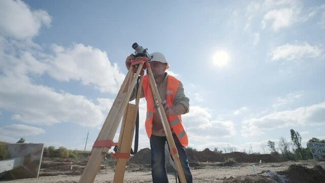 An engineer surveyor takes measurements at the construction of a transformer substation