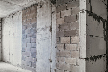 Corner of a concrete wall. Building a house from concrete blocks. Untreated room.