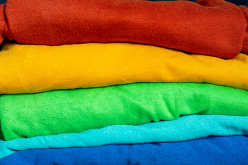 A stack of multicolored fabric without inscriptions. Background with folded clothes. T-shirts of different colors