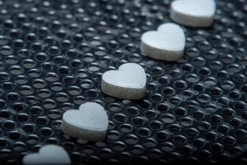 Background with a tablet in the shape of a heart on a dirty floor. Medicines for the heart and to help blood vessels and lungs.