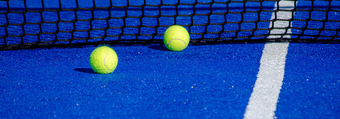 Two balls by the net of a paddle tennis court - obrazy, fototapety, plakaty