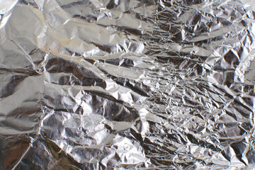 shiny aluminum foil wrap without chocolate candy . Texture of used crumpled aluminium food foil.