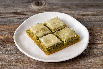 Pistachio baklava on a wooden background. Turkish style pistachio baklava presentation and service. Horizontal view. close up