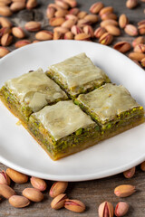 Pistachio baklava on a wooden background. Turkish style pistachio baklava presentation and service. Vertical view. close up