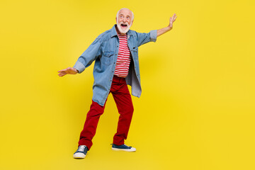 Full length body size view of attractive cheerful grey-haired man dancing having fun rest isolated over bright yellow color background