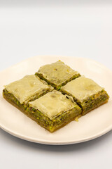 Pistachio baklava on a white background. Turkish style pistachio baklava presentation and service. Vertical view. close up