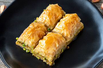 Pistachio baklava on a wooden background. Turkish style pistachio baklava presentation and service. Horizontal view. close up