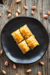Pistachio baklava on a wooden background. Turkish style pistachio baklava presentation and service. Top view. close up