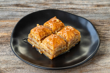 Walnut Baklava on wooden background. Turkish style walnut baklava presentation and service. Horizontal view. close up