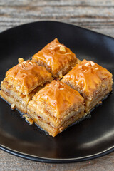 Walnut Baklava on wooden background. Turkish style walnut baklava presentation and service. Vertical view. close up
