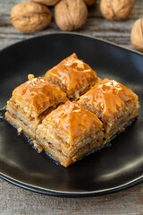 Walnut Baklava on wooden background. Turkish style walnut baklava presentation and service. Vertical view. close up