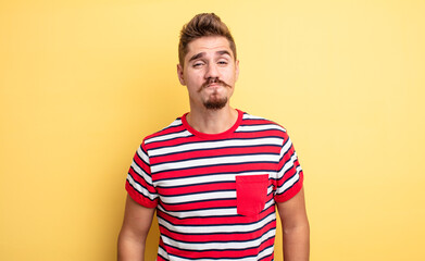 young handsome man pressing lips together with a cute, fun, happy, lovely expression, sending a...