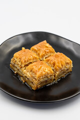 Walnuts baklava isolated on a white background. Turkish style walnut baklava presentation and service. Vertical view. close up