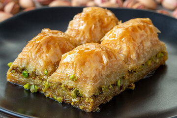 Pistachio baklava on a wooden background. Turkish style pistachio baklava presentation and service. Horizontal view. close up
