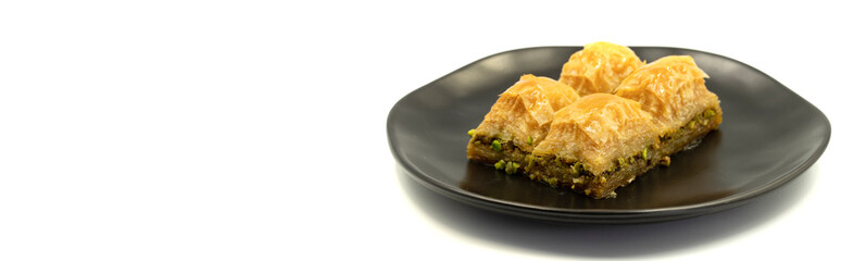 Pistachio baklava isolated on a white background. Turkish style pistachio baklava presentation and service. Empty space for text. Copy space