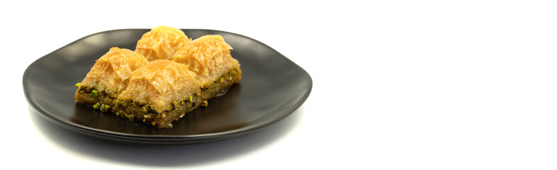 Pistachio baklava isolated on a white background. Turkish style pistachio baklava presentation and service. Empty space for text. Copy space