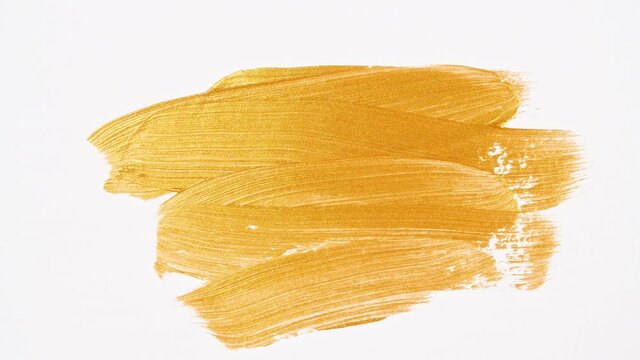 Abstract brushstrokes of gold paint brush applied isolated on a white background. Gold paint smear texture. Golden sparkling textured artistic illustration. Smears of cosmetics. High quality 4k 