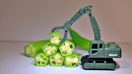 Stacking okra with excavator grapple 