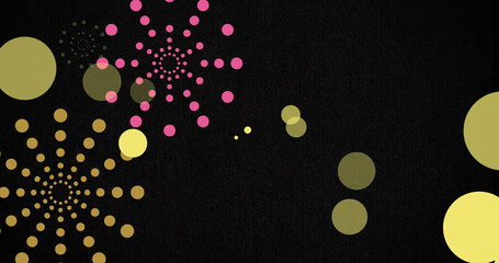 Image of green and orange firework explosions and bokeh yellow light spots on black background