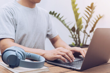 young man using laptop typing on keyboard