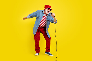 Full length body size view of attractive cheery grey-haired man singing hit having fun isolated over vivid yellow color background
