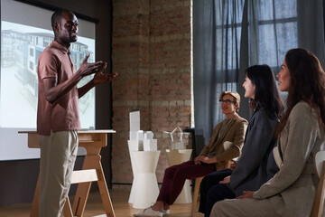 African young architect presenting architectural project to colleagues at conference