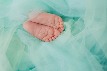 Baby's feet under a green blanket