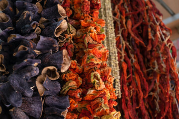 Dried vegetables in the traditional way strung on threads and hung on the street. Dried red hot and sweet peppers.