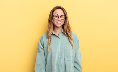 pretty caucasian woman looking happy and friendly, smiling and winking an eye at you with a...
