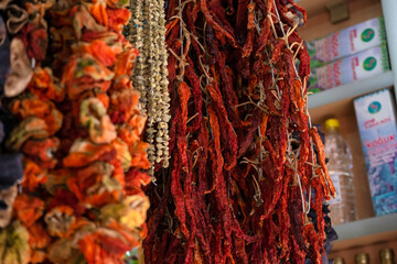 Dried vegetables in the traditional way strung on threads and hung on the street. Dried red hot and sweet peppers.