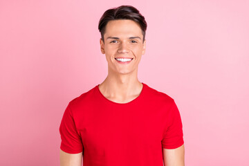 Photo of funny charming young man wear red t-shirt smiling isolated pink color background