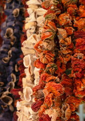 Obraz na płótnie Canvas Dried vegetables in the traditional way strung on threads and hung on the street. Dried red hot and sweet peppers, eggplant
