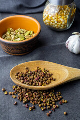 cardamon clay pot, sichuan paper in wood spoon, chilli paper and juniper berry, garlic and corn in glass jar