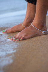 married women wears Anklet, toe ring and standing towards Beach Waves.