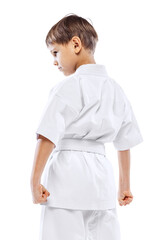Cropped portrait of little boy in white kimono, martial art sportsman posing isolated over white...