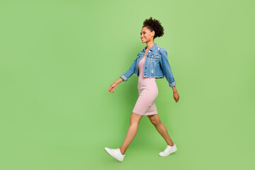 Full body profile photo of pretty young lady go wear dress shirt sneakers isolated on green background